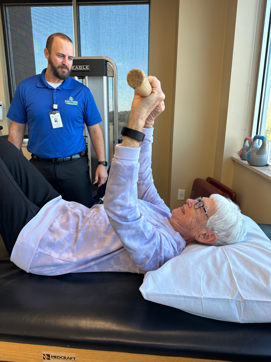 A physical therapist instructs a patient.